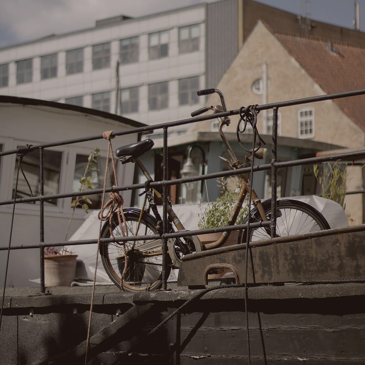 A bicycle, ropes, and weathered metal on a boat in Copenhagen harbour.